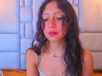 A brunette girl with soft, radiant skin, a slim body that moves with grace and energy. Her black, straight, shiny hair falls in soft waves over her shoulders, highlighting her lively face. She has a warm and contagious smile that lights up her expression and reflects her cheerful and laughing personality. Her attitude is determined and confident, always with a spark of confidence that is noticeable in her bearing and the way she interacts with others. She has a lively look that shows her enthusiasm for life, leaving an impression of freshness and positivity wherever she goes.